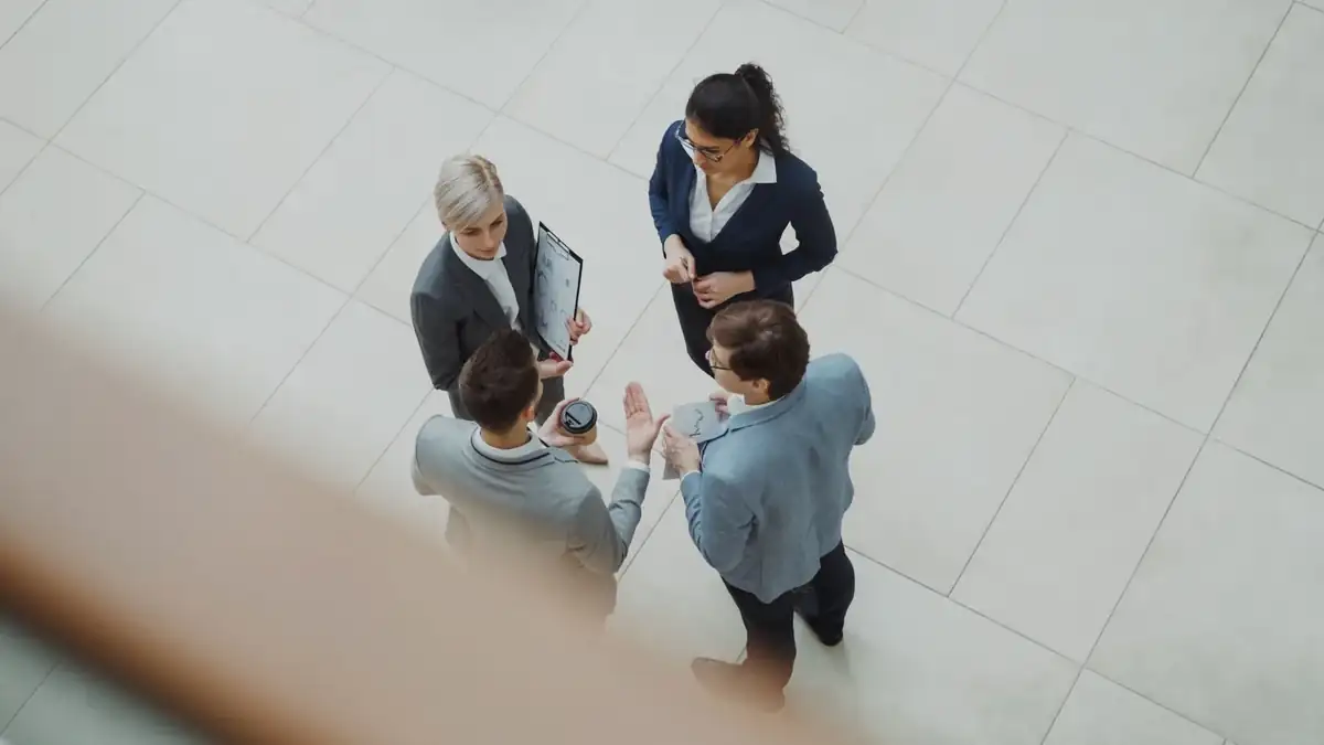 Four business professionals discussing a document and shared information