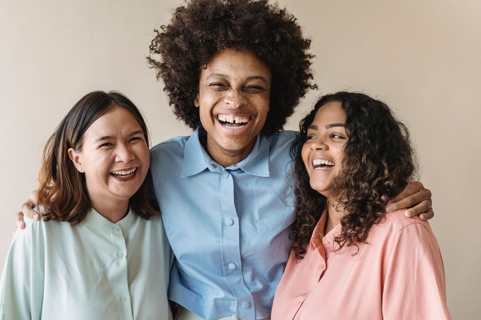 Three colleagues smiling together in a bright office