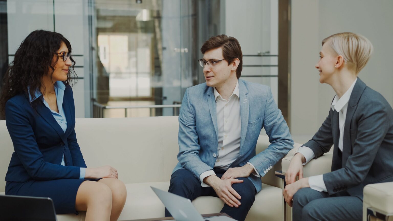 Colleagues in business attire discussing a plan in a bright office