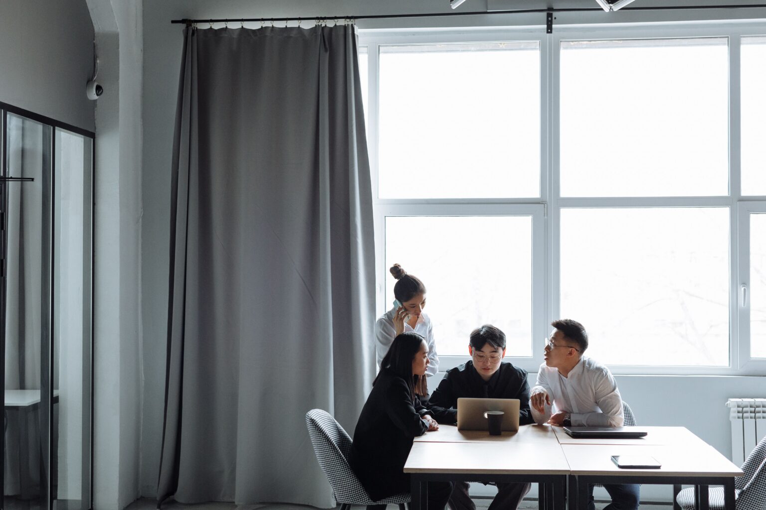 A team collaborating around a table with laptops